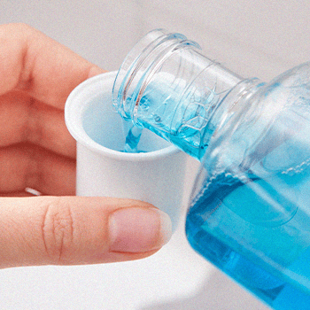 Pouring a mouth wash inside a small container
