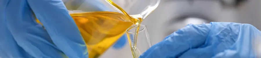 A doctor pouring urine into another jar in a laboratory