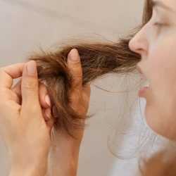 Woman looking at her hair close up 