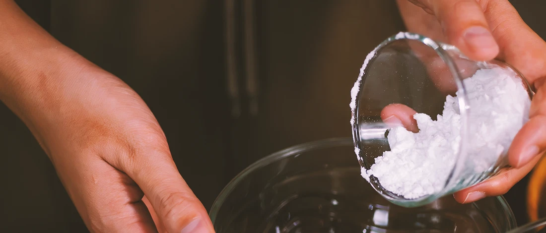 A person pouring powder into a bowl