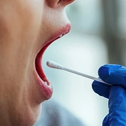 A close up shot of a doctor getting a saliva sample