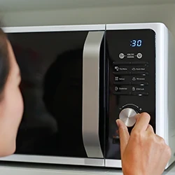 A woman using a microwave to heat urine